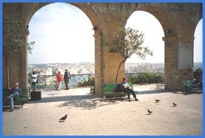 Anne, resting in the Upper Barrakka Gardens, with the Grand Harbour and the Three Cites in the background